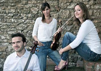 iMAGE DES TROIS MUSICIENS DEVANT UN MUR EN PIERRE